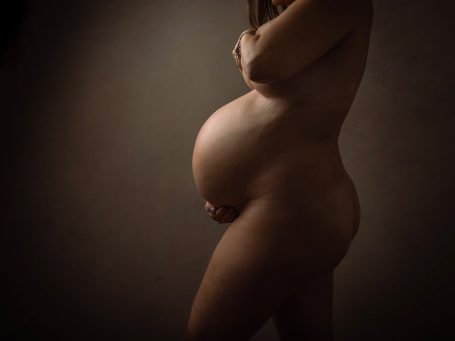 Silueta de mujer embarazada posando de lado, mostrando su barriguita.