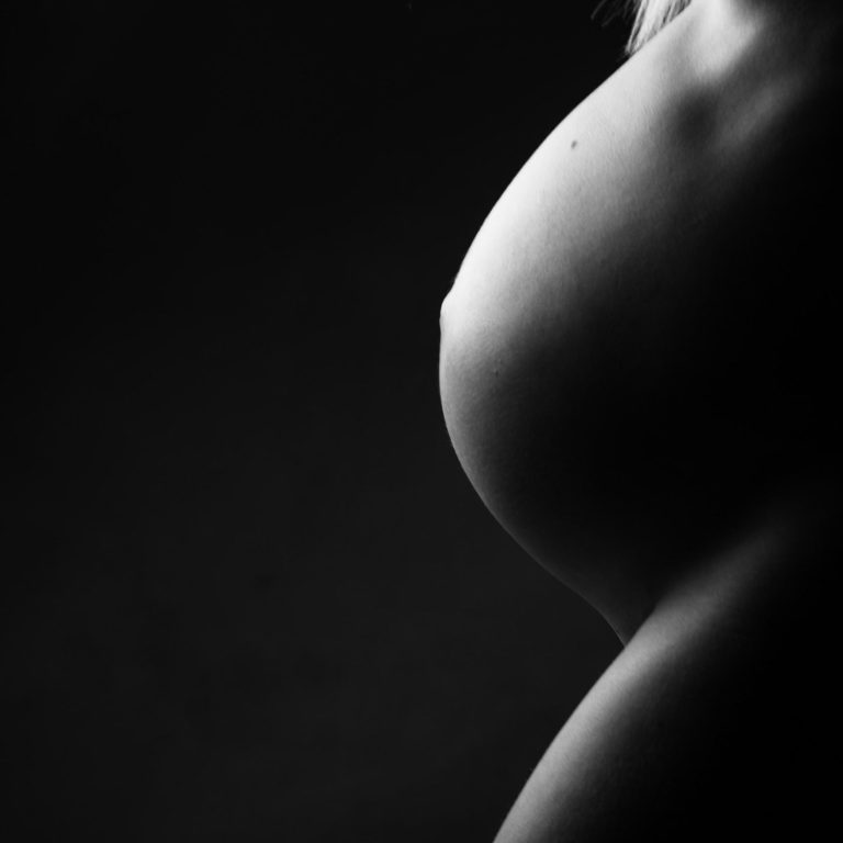Silueta de un torso femenino en blanco y negro, resaltando la forma del pecho.